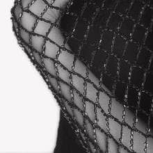 Close-up shot of a person's arm wrapped in intricate, dark, mesh-like netting. The net material has a diamond pattern and fits snugly against the skin. Part of the Presence Series, this image boasts a 10/10 contrast with its plain white background highlighting the netting and skin beautifully.