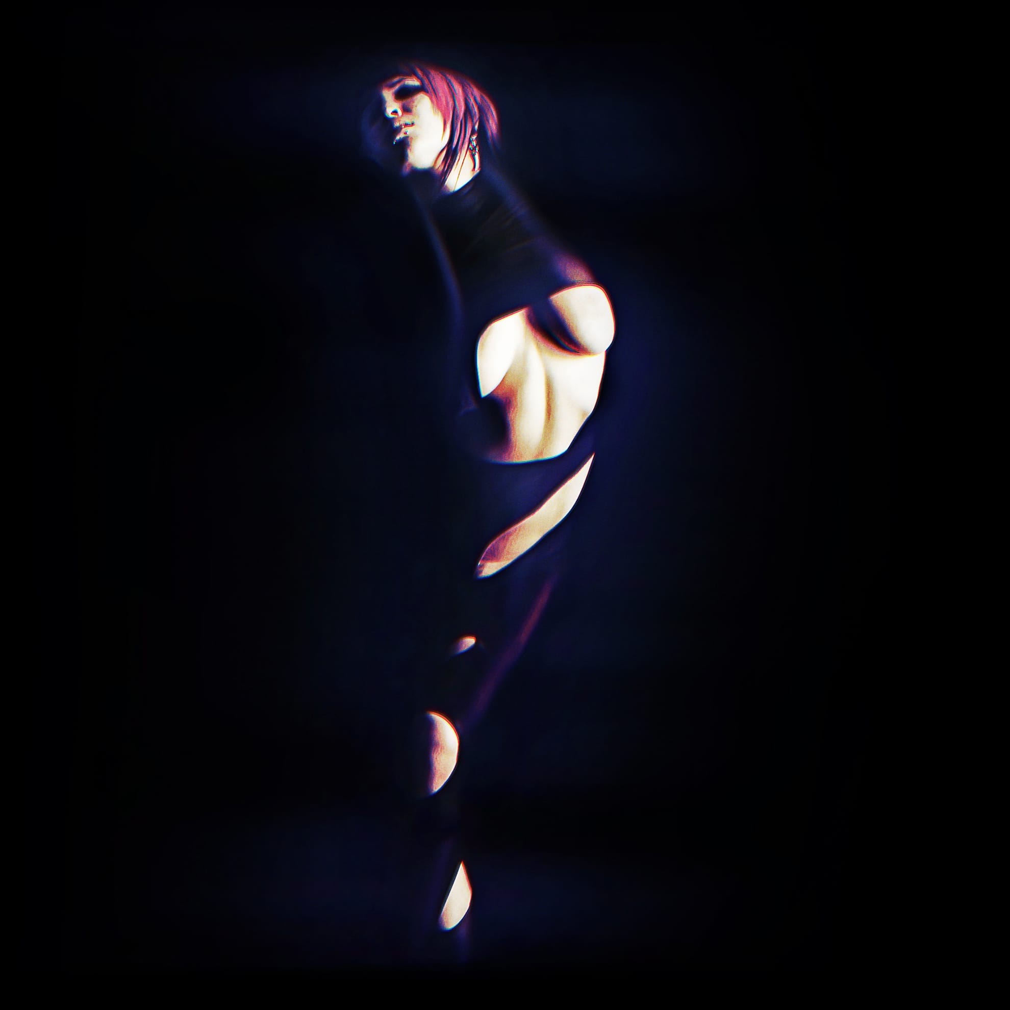 A person with a soft pink bob haircut is posing in a dark environment. They are wearing a black outfit with multiple cutouts, revealing parts of their skin. The background is almost entirely black, making the figure dramatically highlighted by light, creating an artistic, surreal effect, as if torn from reality.