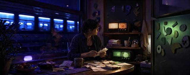 A person counts money at a table as radios play softly and a train passes by the window.
