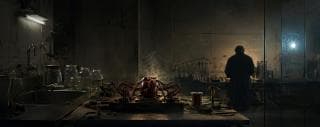 A large artificial heart with wires rests on a table as someone works in the lab behind, symbolizing strength and spirit.