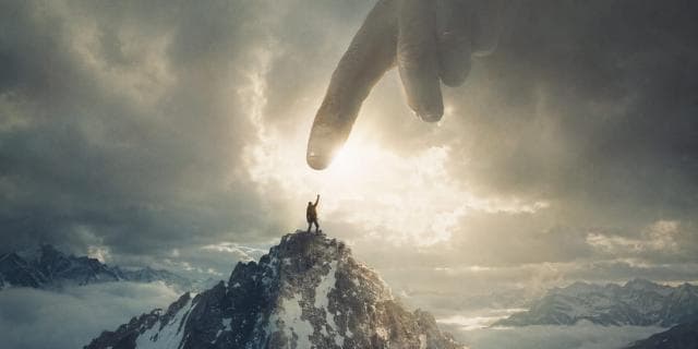 Person on a mountain peak reaches for a hand from the sky amid dramatic clouds, suggesting satire and subversion.