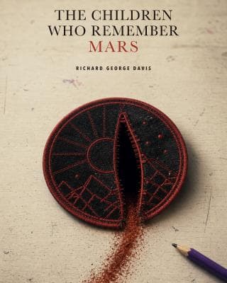 A black-and-red embroidered Mars mission patch split by a dark opening on a worn school desk, with red dust trailing towards a purple pencil. Cover text reads The Children Who Remember Mars by Richard George Davis.